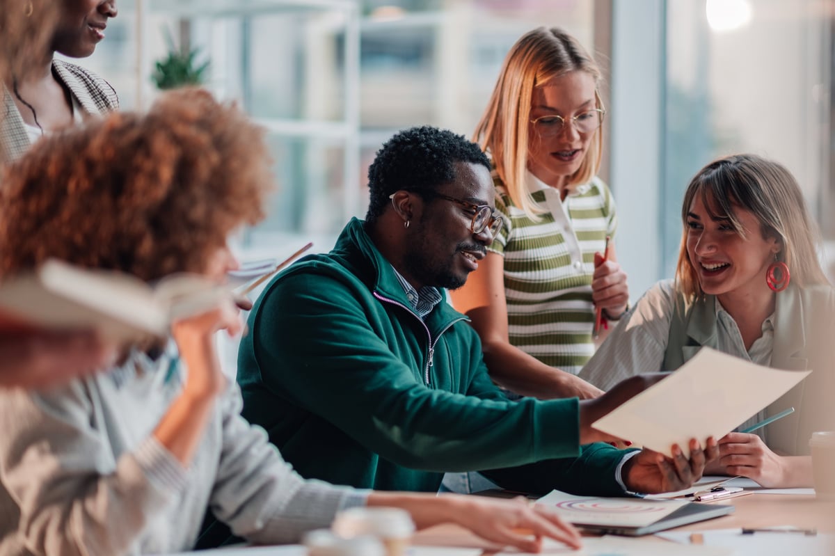 Young diverse business team working together in a modern office, sharing ideas and laughing during a meeting